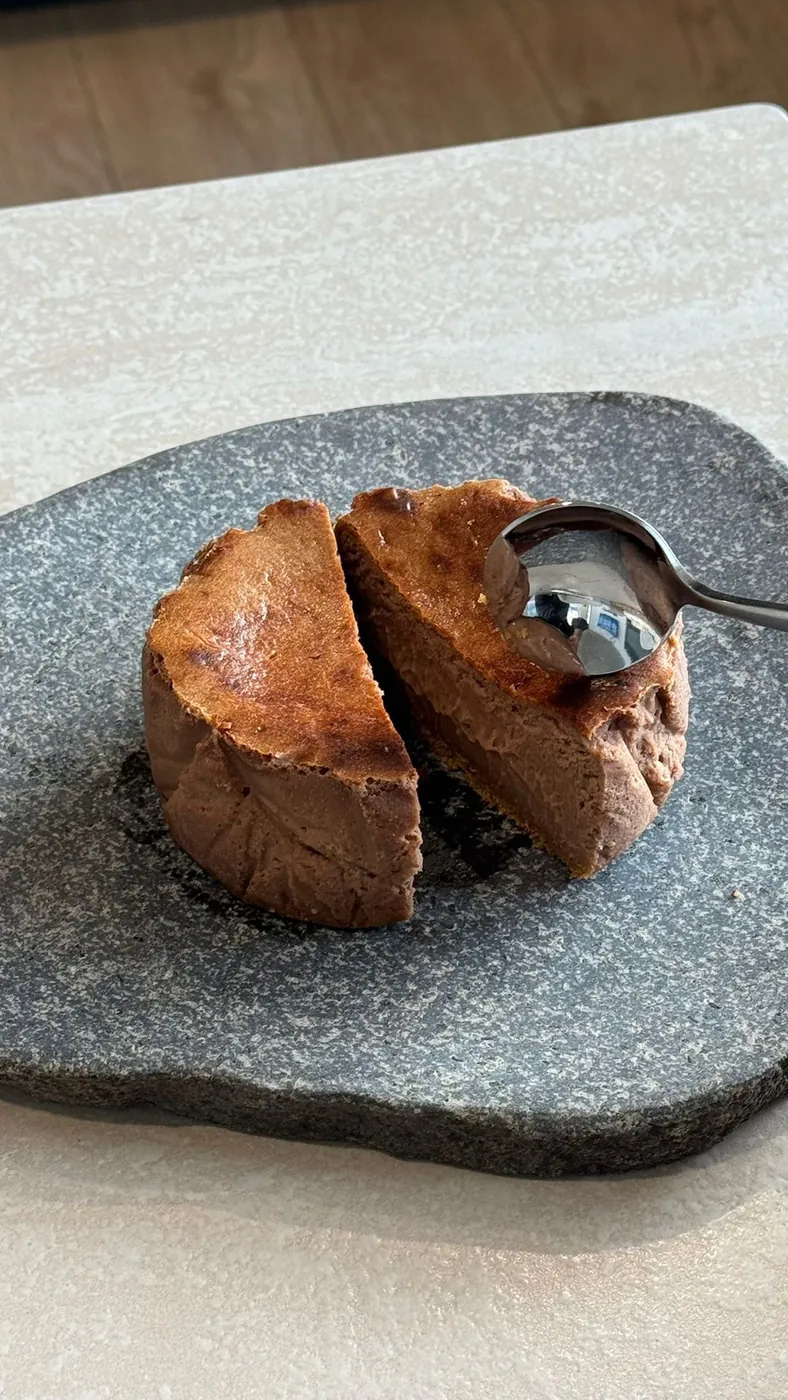 A Nutella tartza cut open on a stone slab, a spoon in the slice
